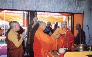 The elder monks and fourfold assembly of disciples passing offerings to the Venerable Master